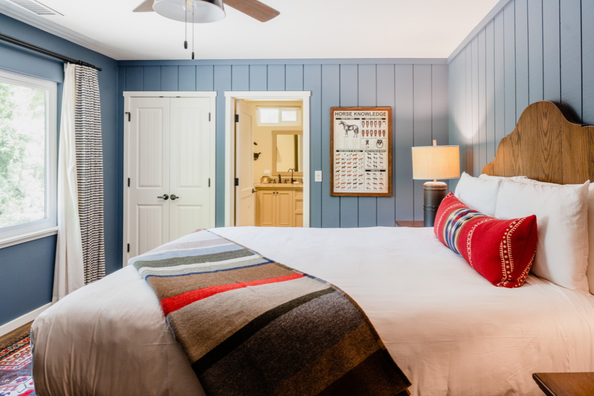 a bed with a blanket and a ceiling fan