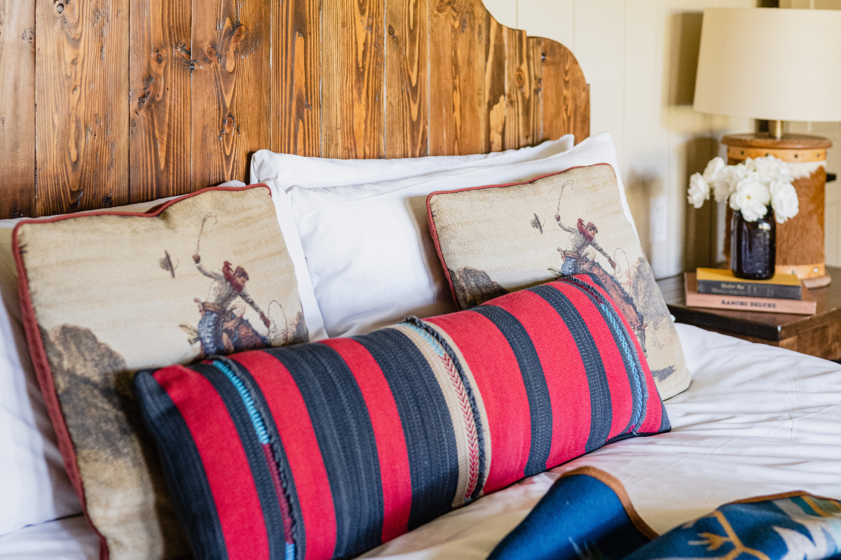 a bed with pillows and a lamp on the side