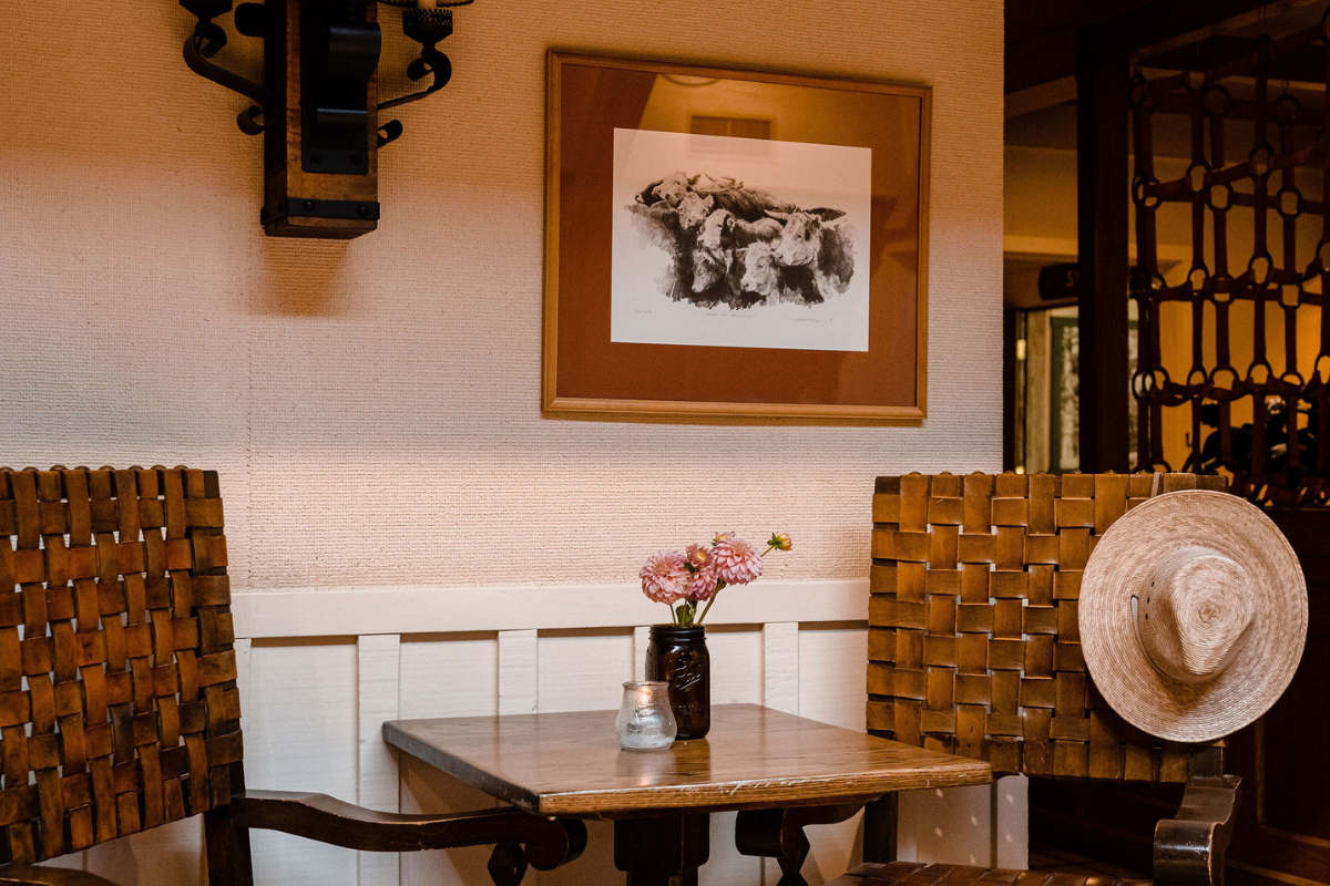 a table with chairs and a vase of flowers on it