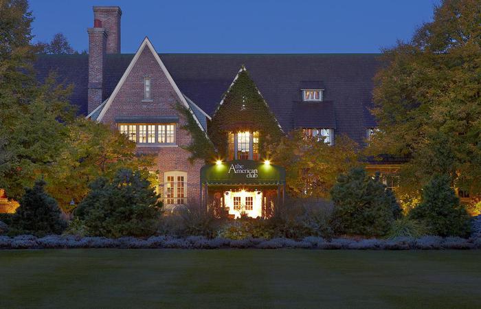 a large brick house with a lawn and trees