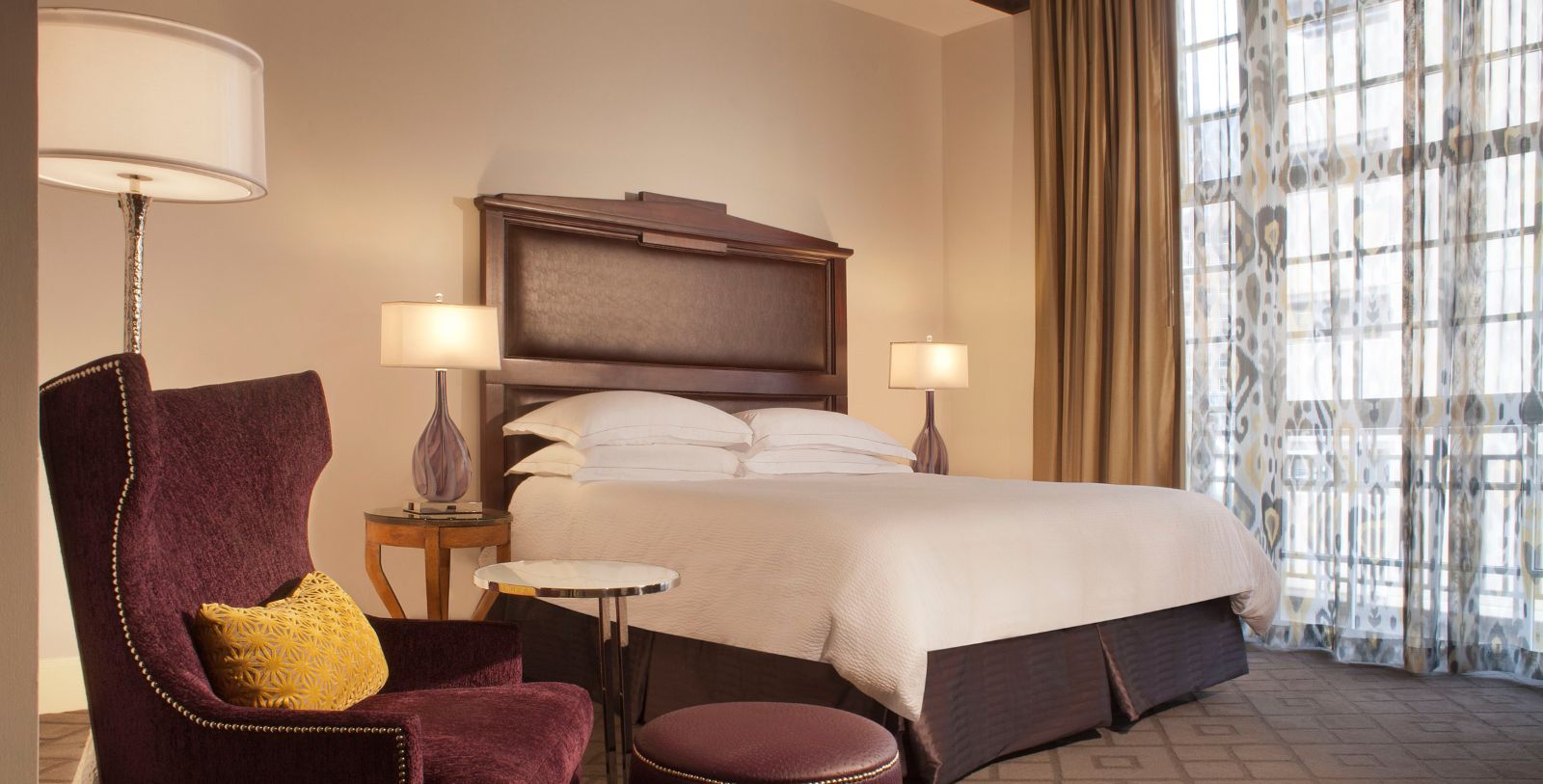a bed with a headboard and two lamps