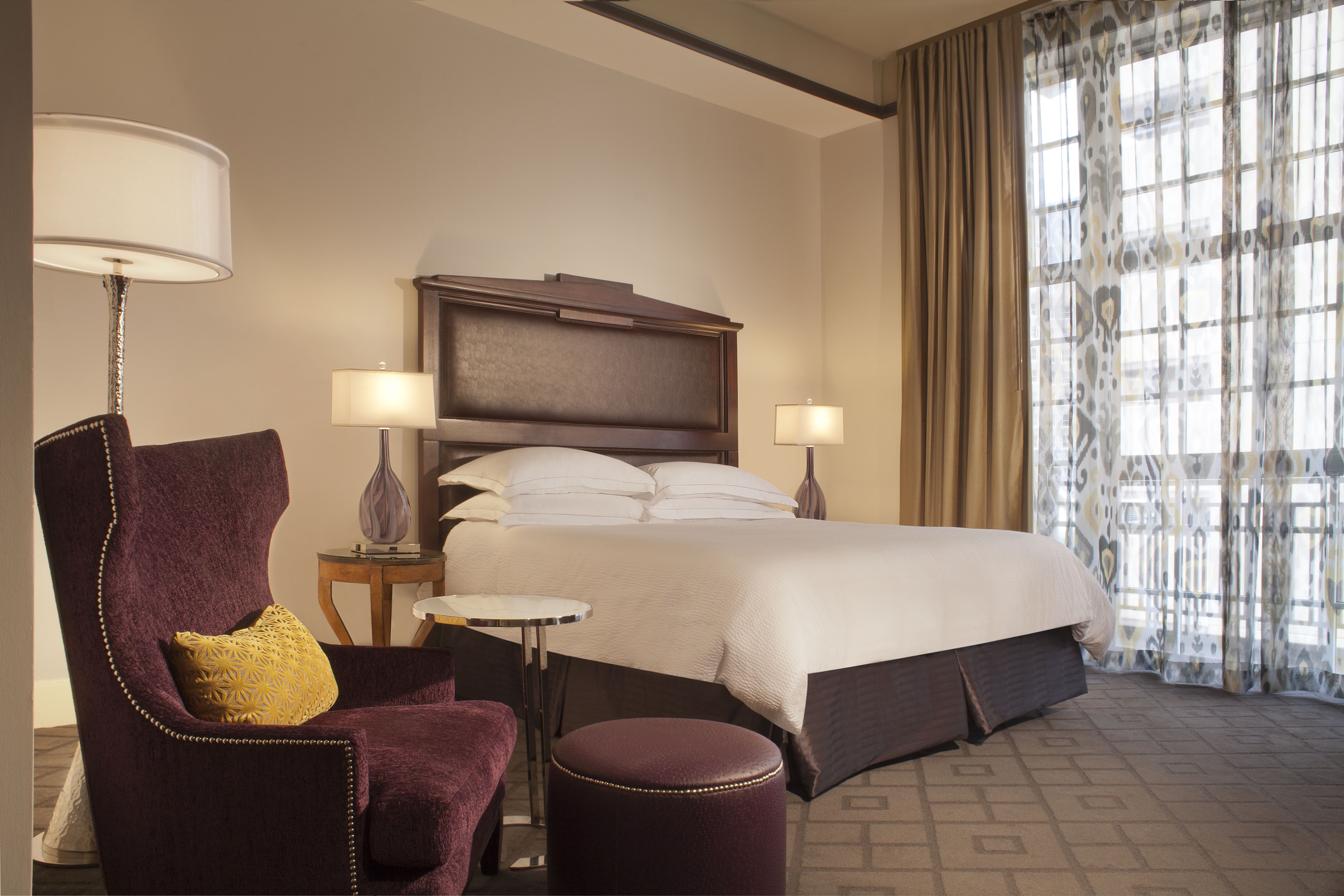 a hotel room with a bed and chairs