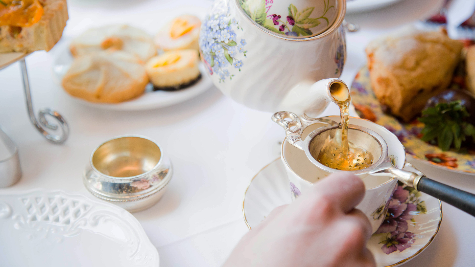 a person pouring tea into a teapot