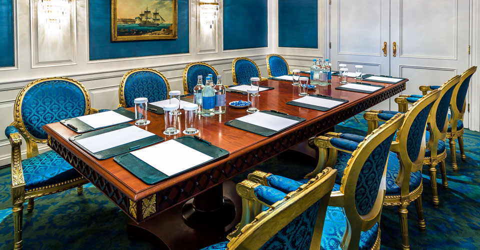 a table with empty chairs and bottles of water