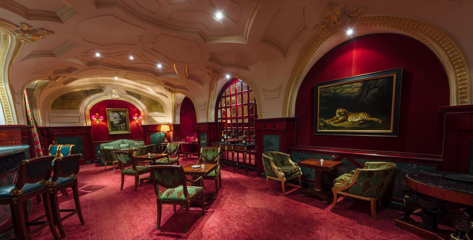 a room with red carpet and tables and chairs