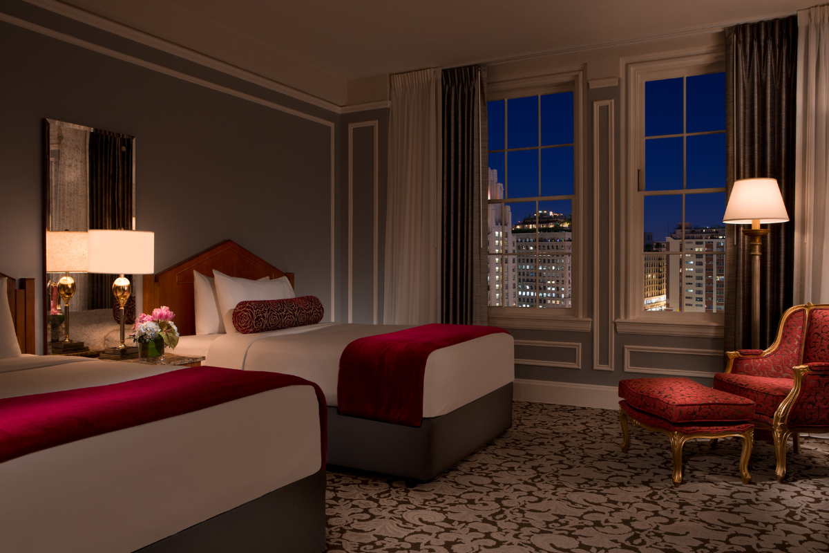 a room with two beds and a stool