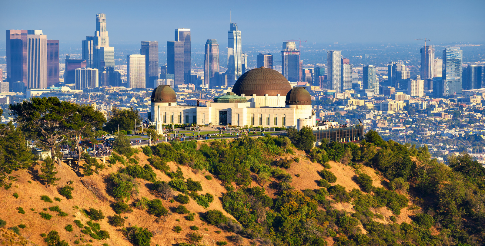 a large building with a dome on top of a hill with a city in the background