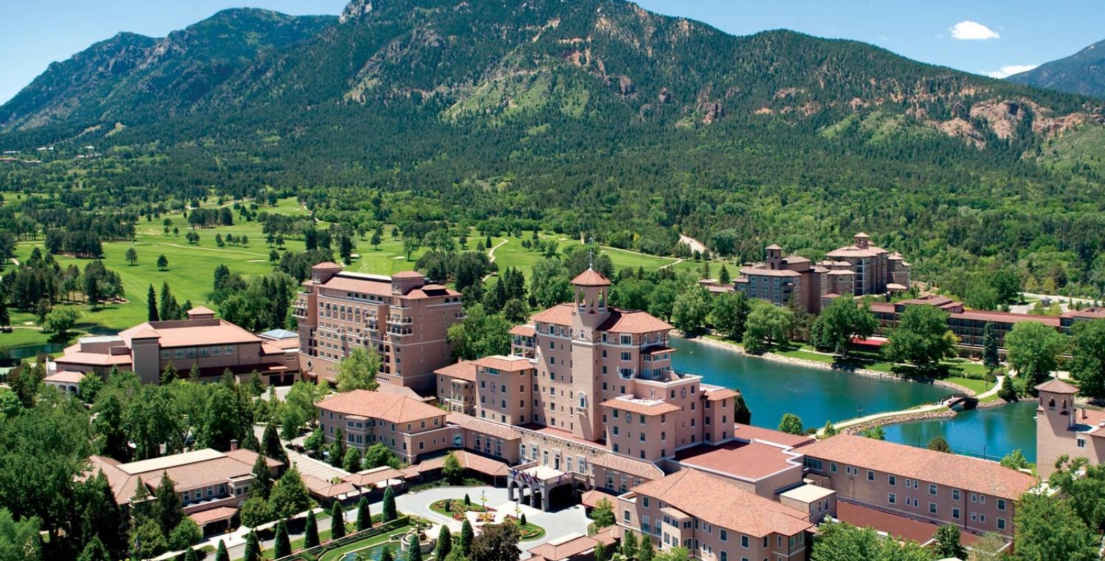 a large building surrounded by trees and mountains