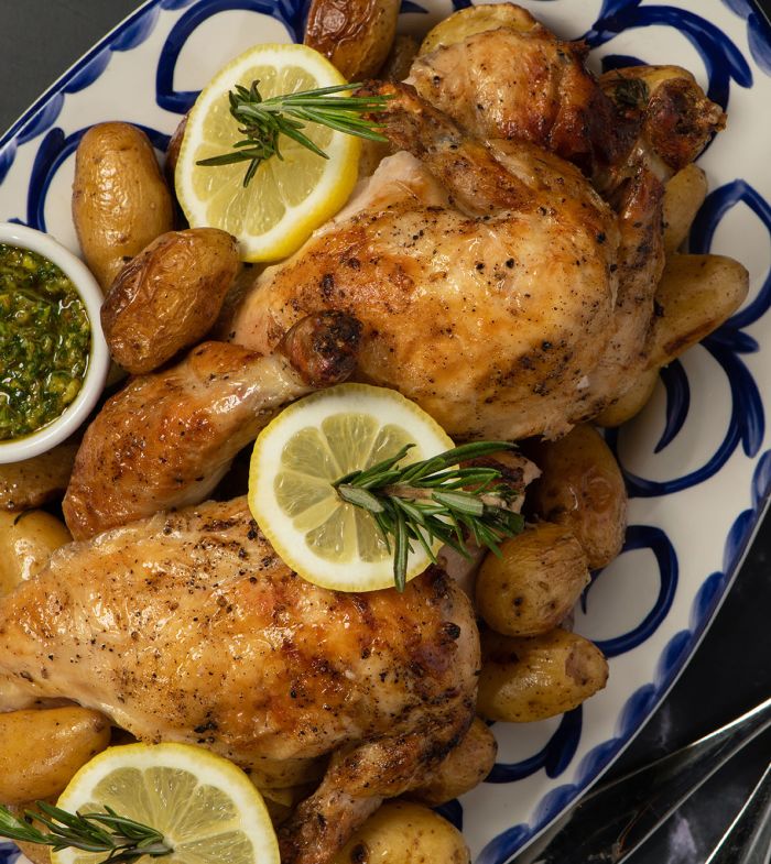 a plate of food with lemon slices and potatoes