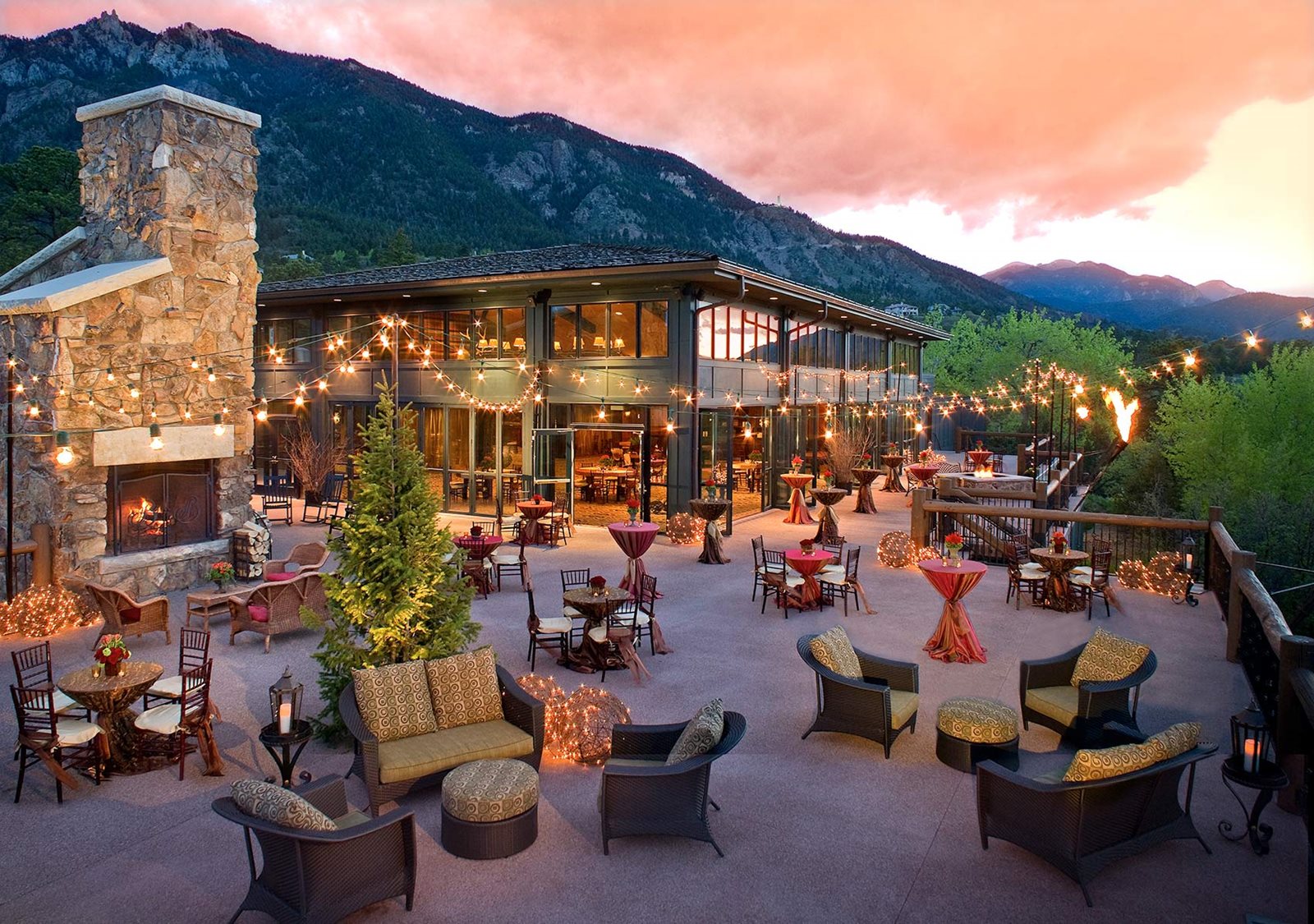 a patio with chairs and tables and lights on it