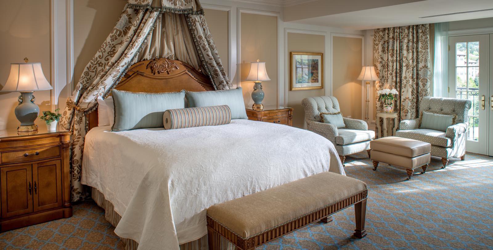 a bedroom with a canopy bed and chairs