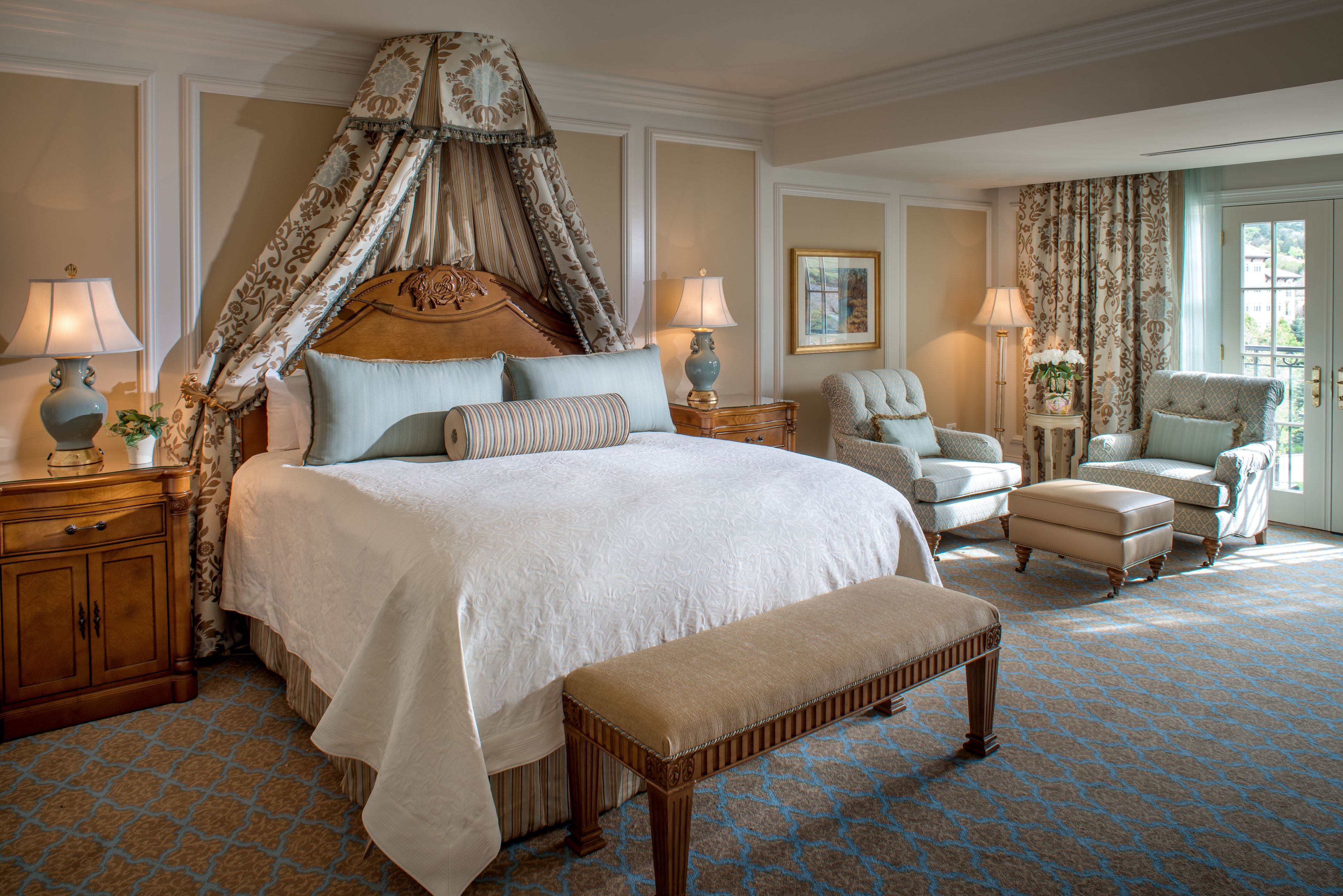a bedroom with a canopy bed and chairs