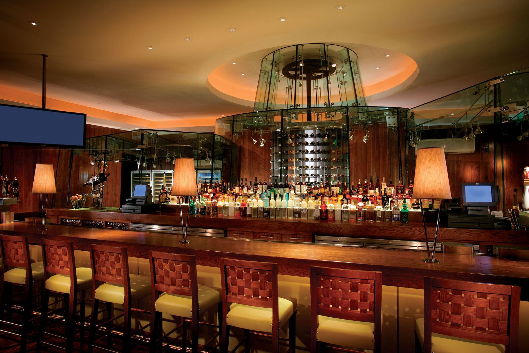 a bar with a row of chairs and a large glass ceiling