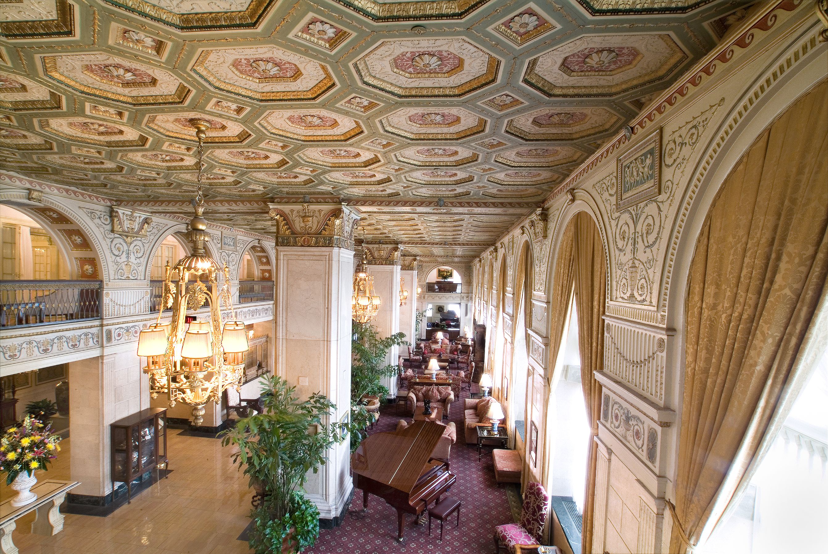 a room with tables and chairs in a large ornate room