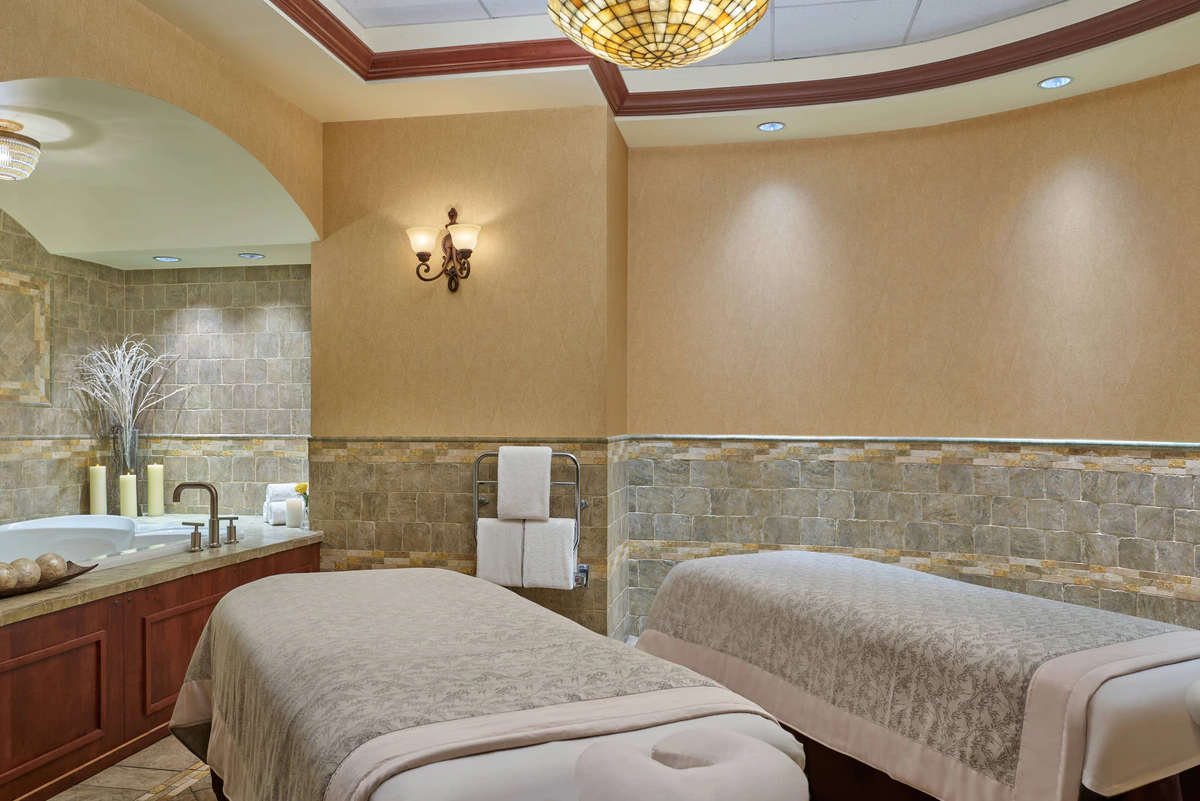 a room with two beds and a sink