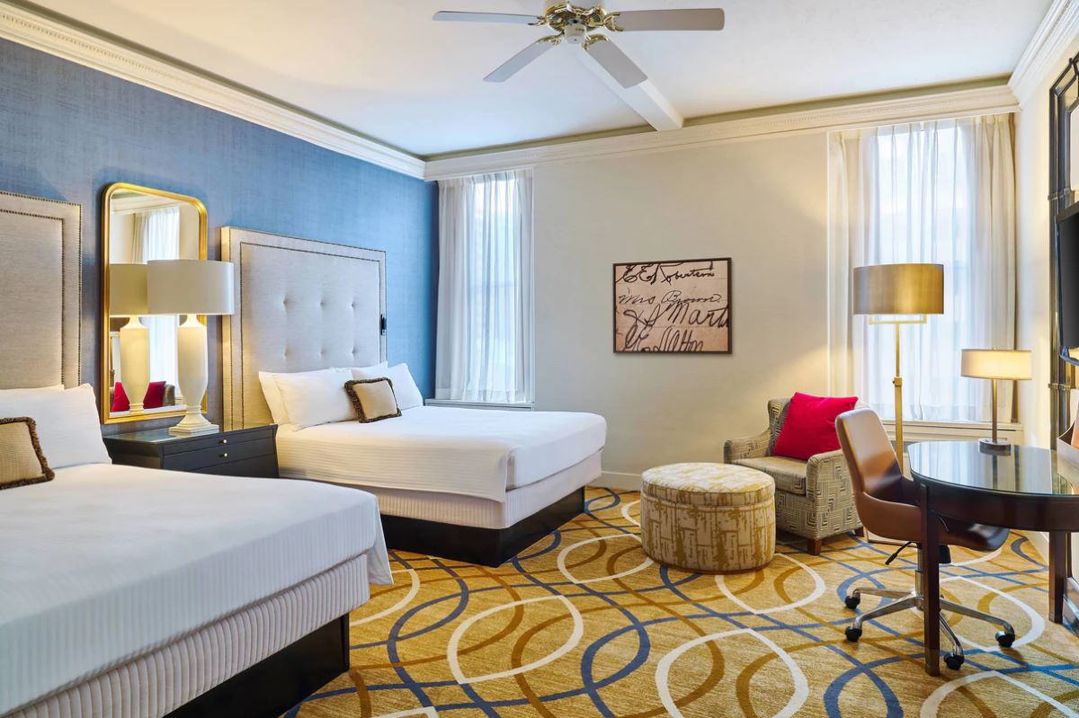 a room with two beds and a chair