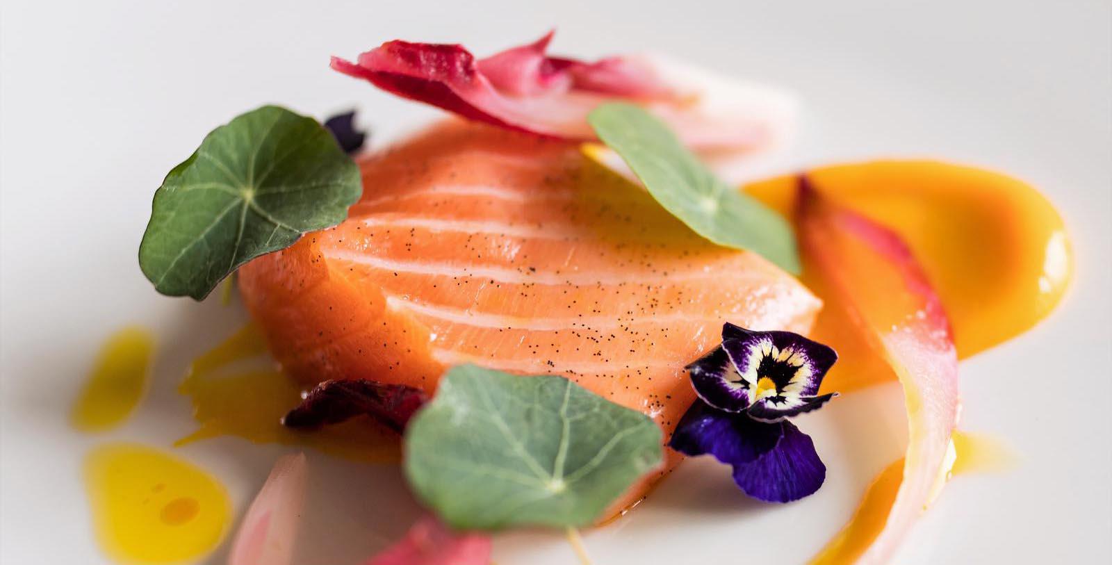 a piece of salmon with flowers on a plate