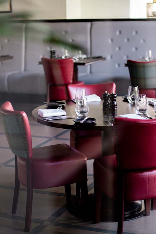a table with red chairs and silverware