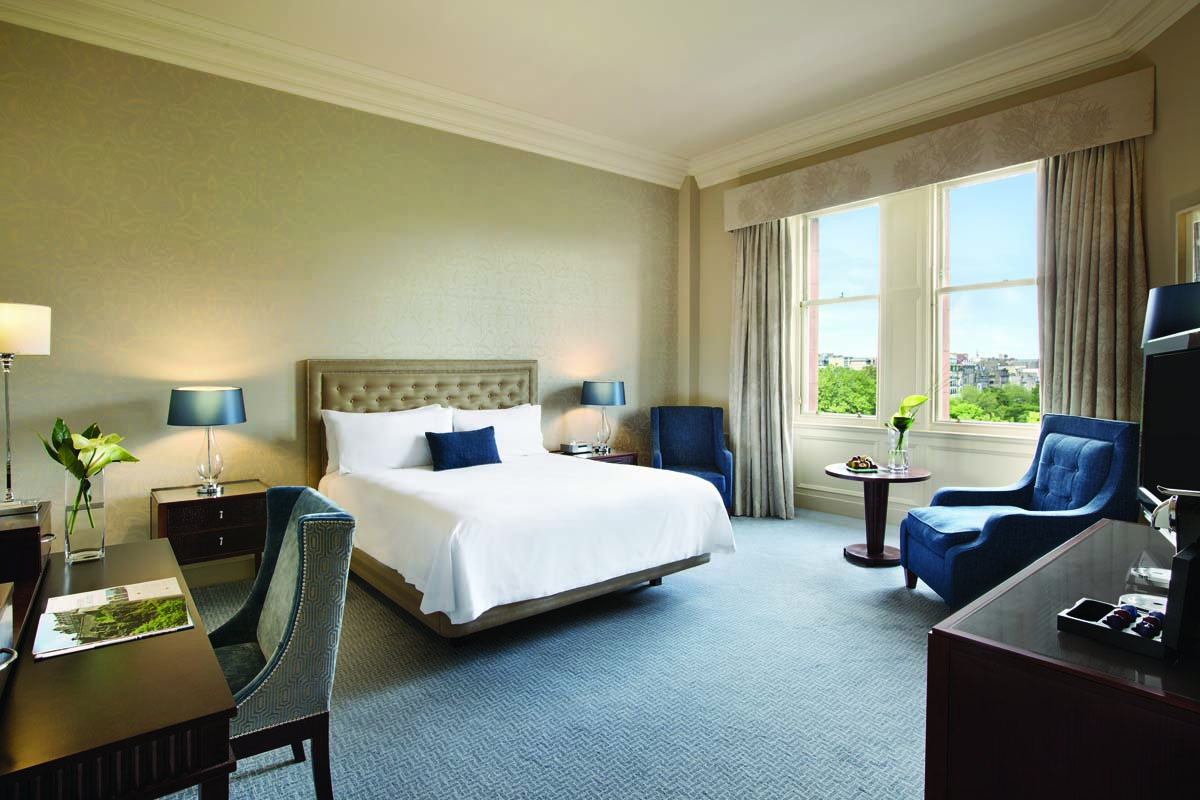 a room with a bed and chairs
