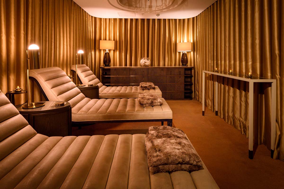 a room with brown curtains and tan chairs