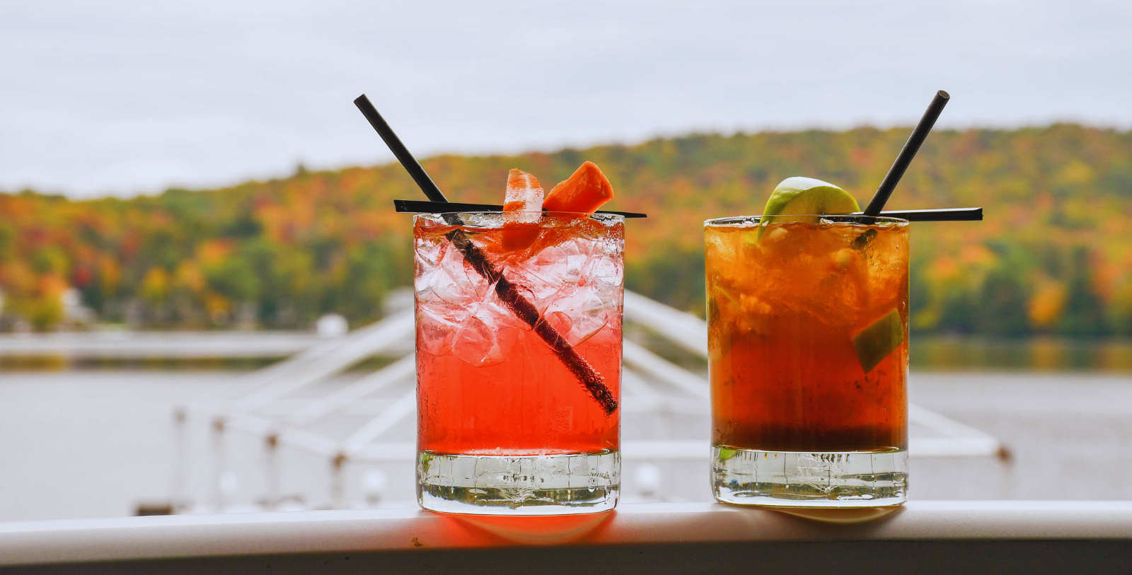 two glasses of drinks on a ledge