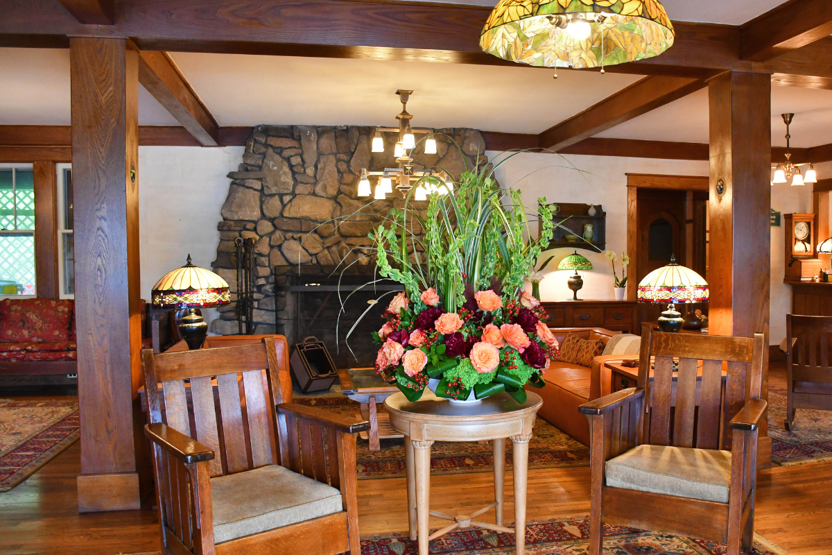 a room with chairs and a table with flowers
