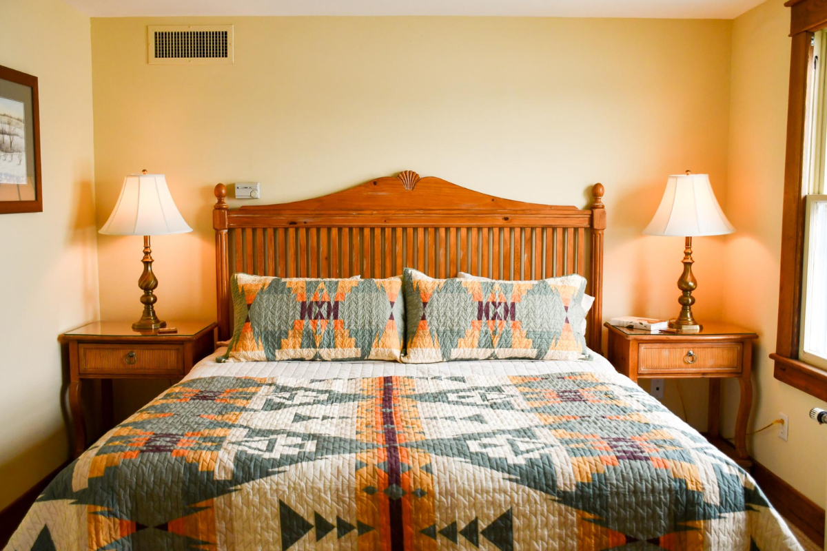 a bed with a wooden headboard and lamps