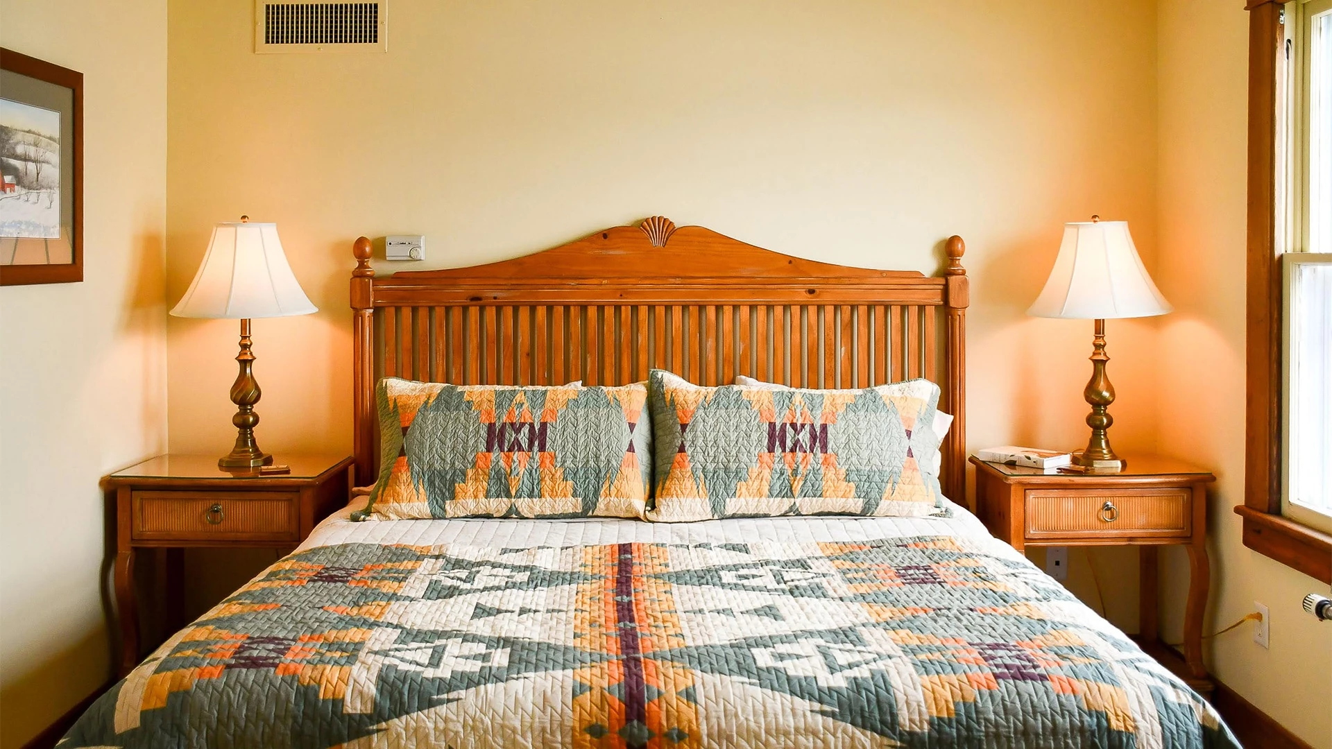 a bed with a wooden headboard and lamps