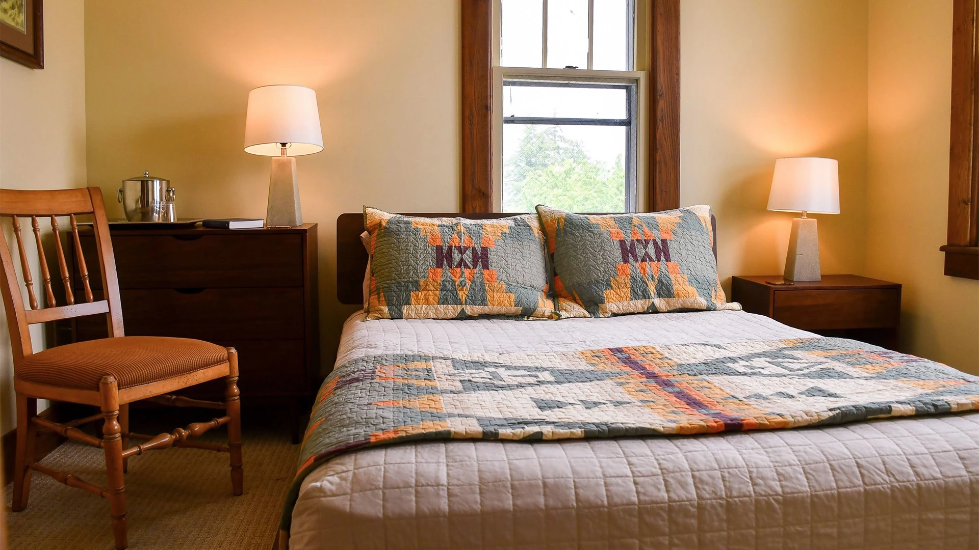 a bed with pillows and a lamp in a room