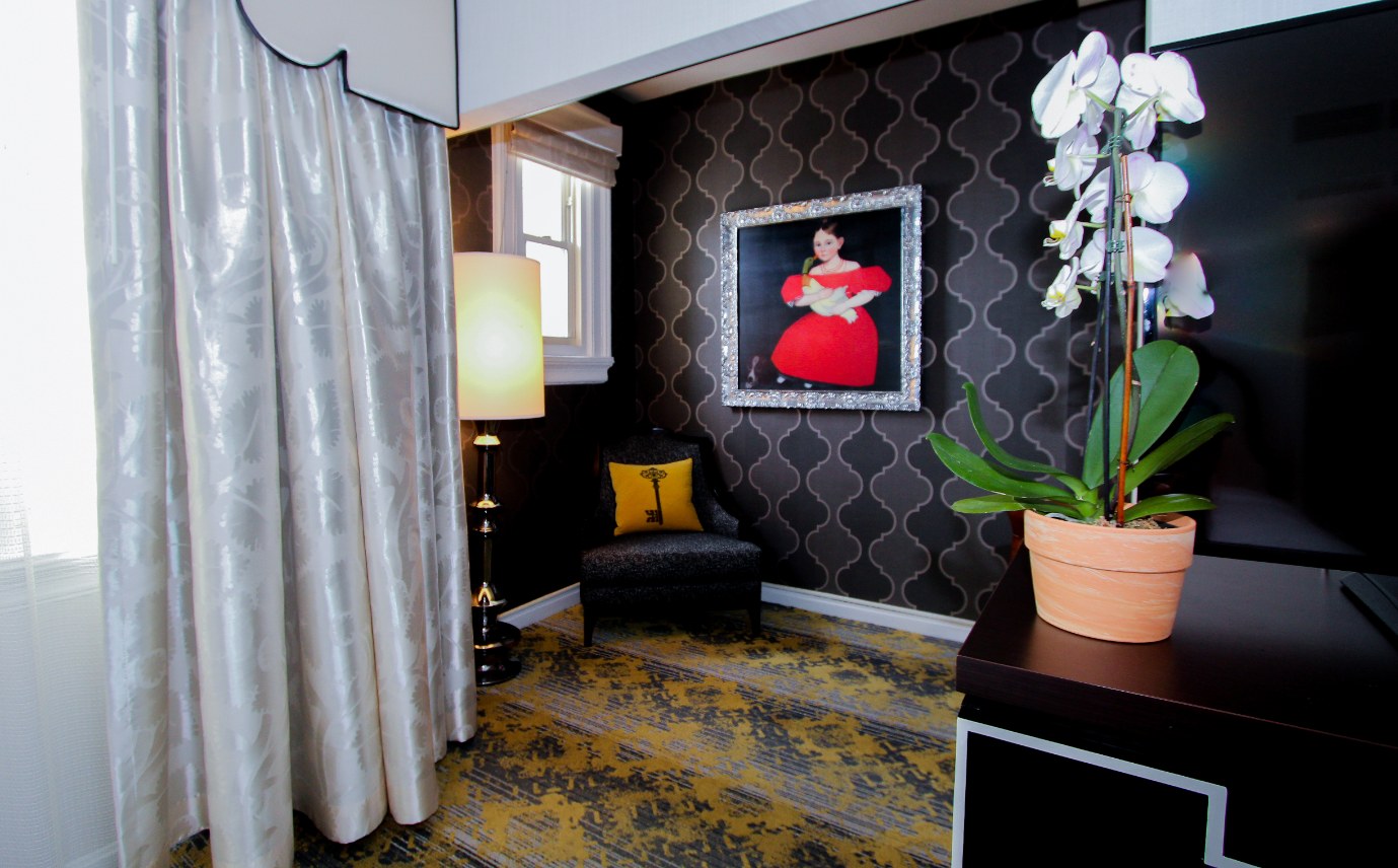 a room with a painting of a woman in a red dress