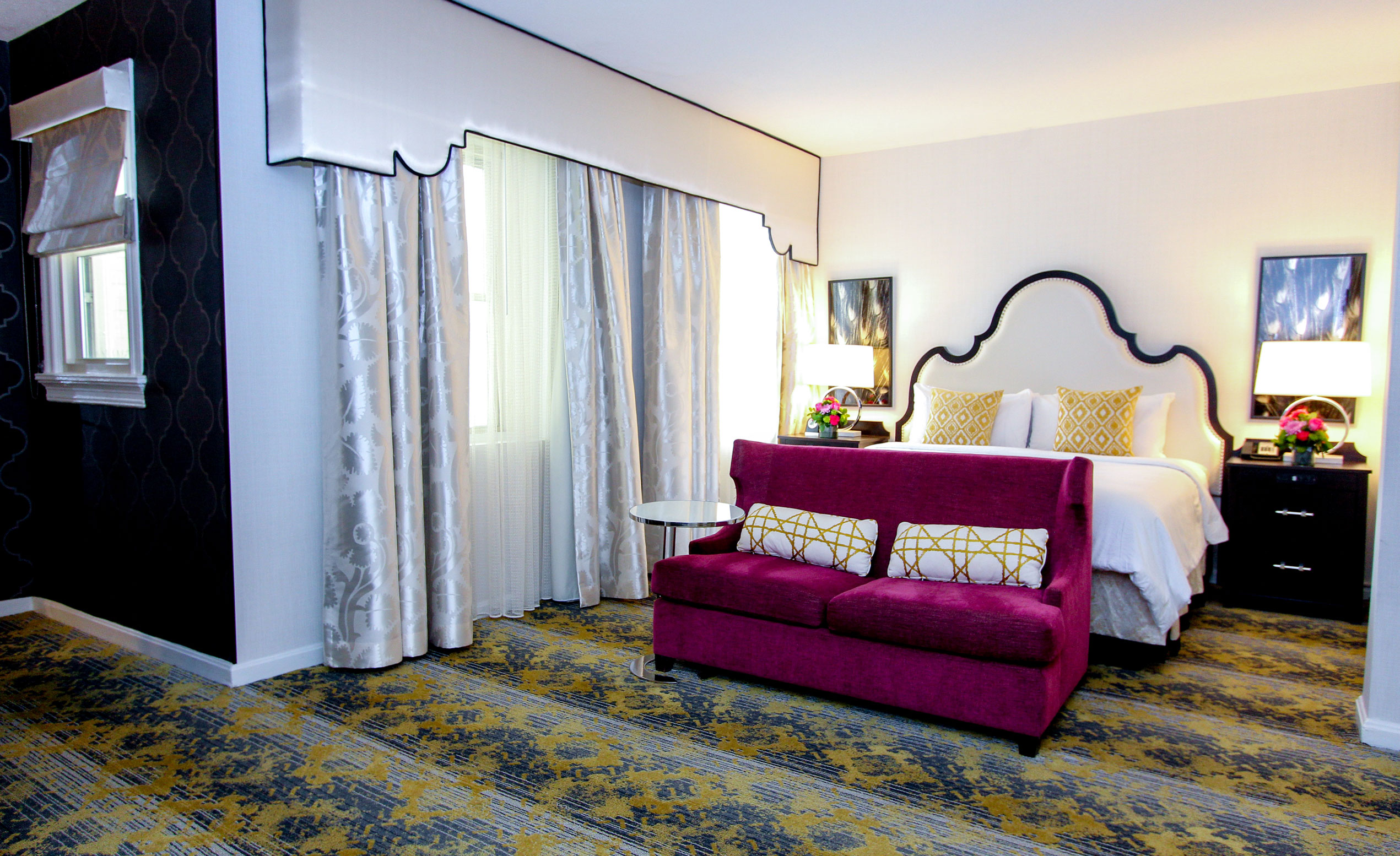 a bed with a purple couch in a room with curtains
