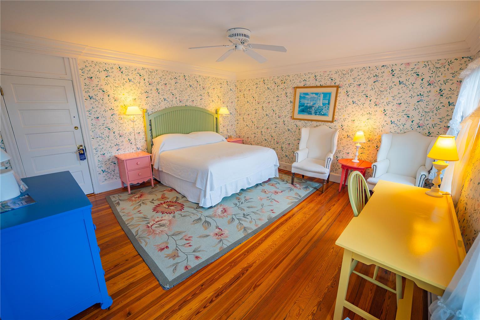 a room with a bed and chairs