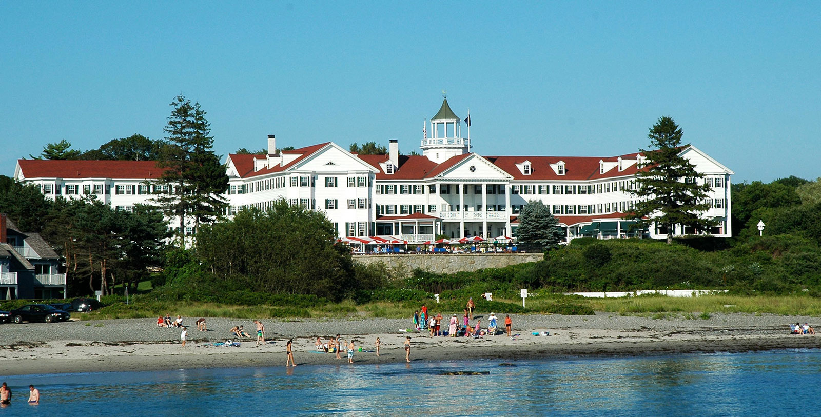 a large white building with a red roof with Disney's Grand Floridian Resort & Spa in the background