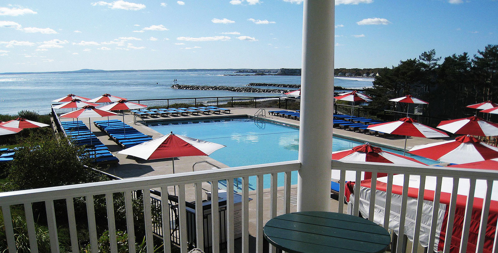 a pool with umbrellas and chairs on a deck