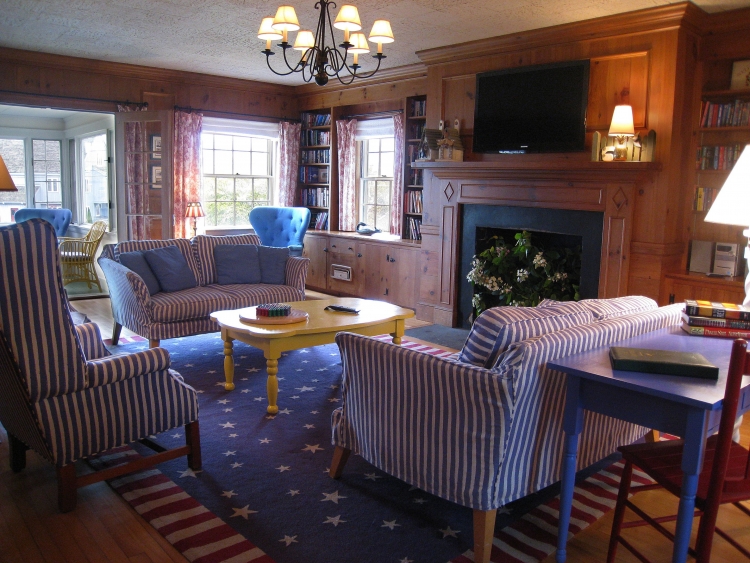 a living room with a fireplace and striped chairs