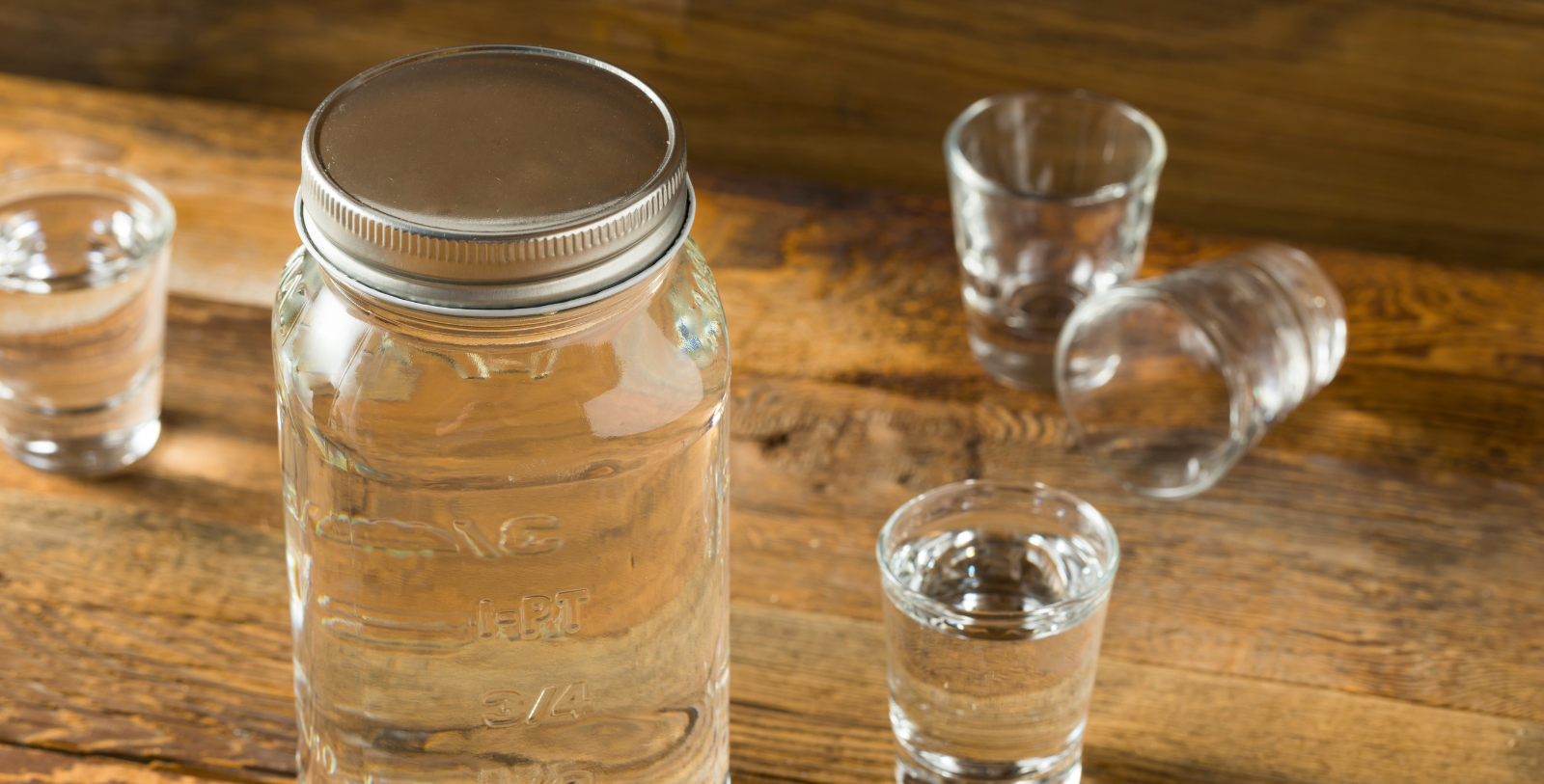 a glass bottle and shot glasses