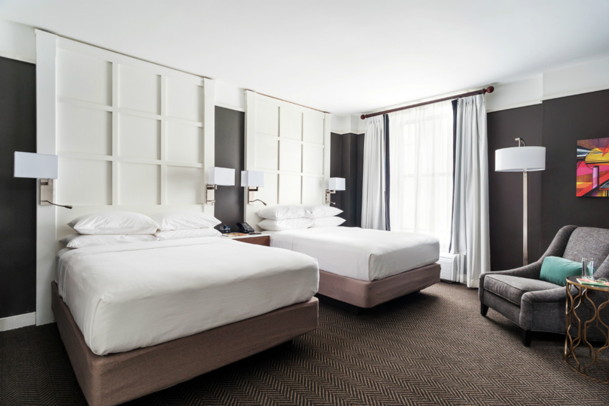 a room with two beds and a chair
