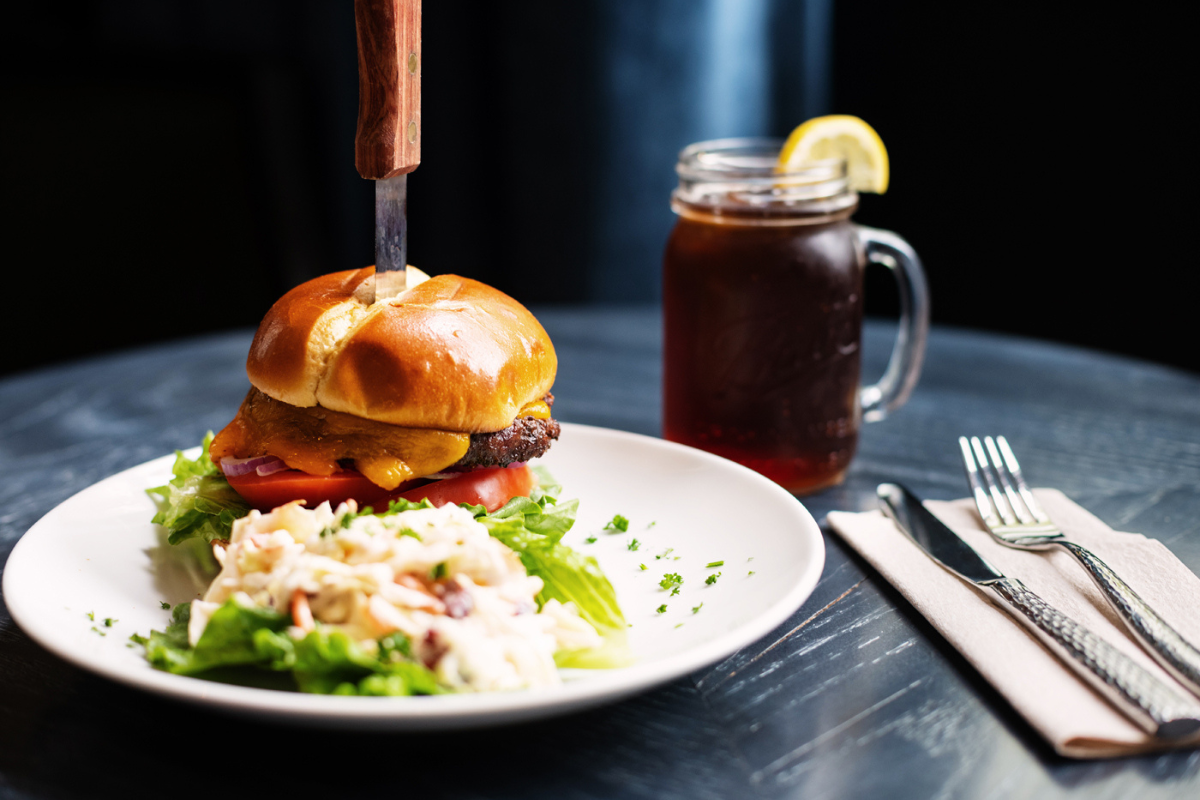 a burger with a knife stuck in the bun