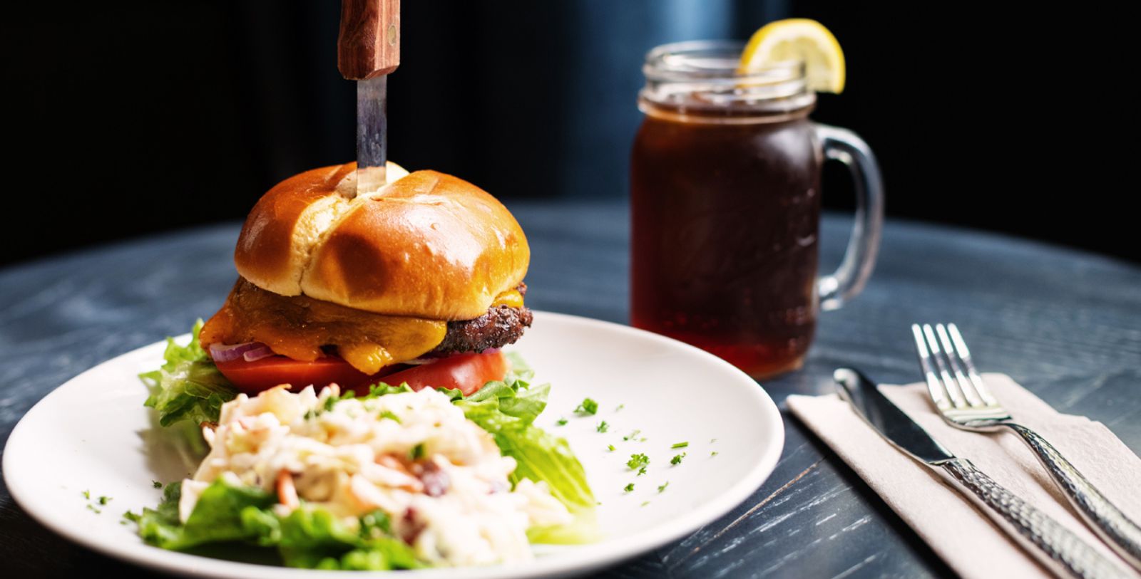 a burger with a knife stuck in the bun