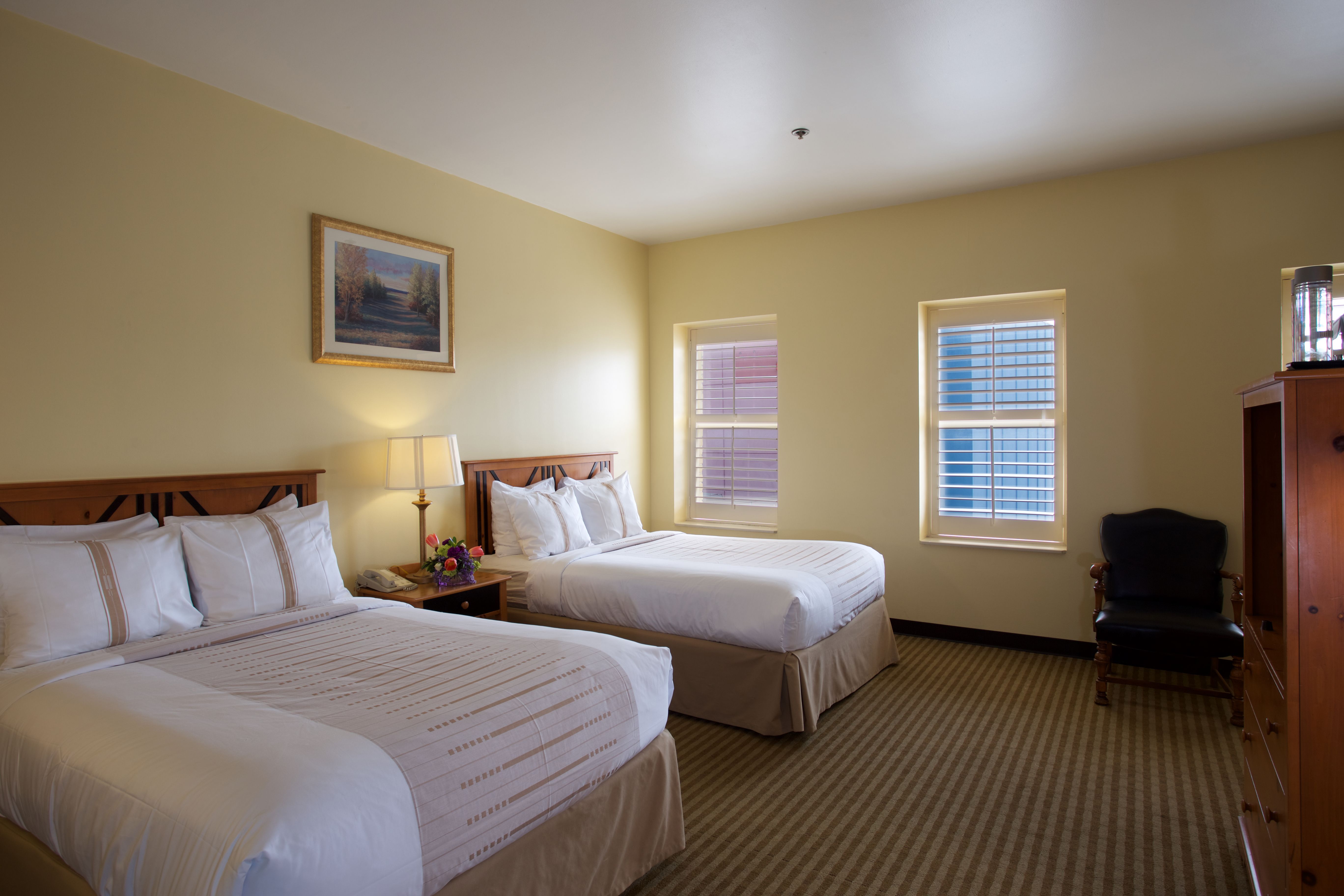 a room with two beds and a chair