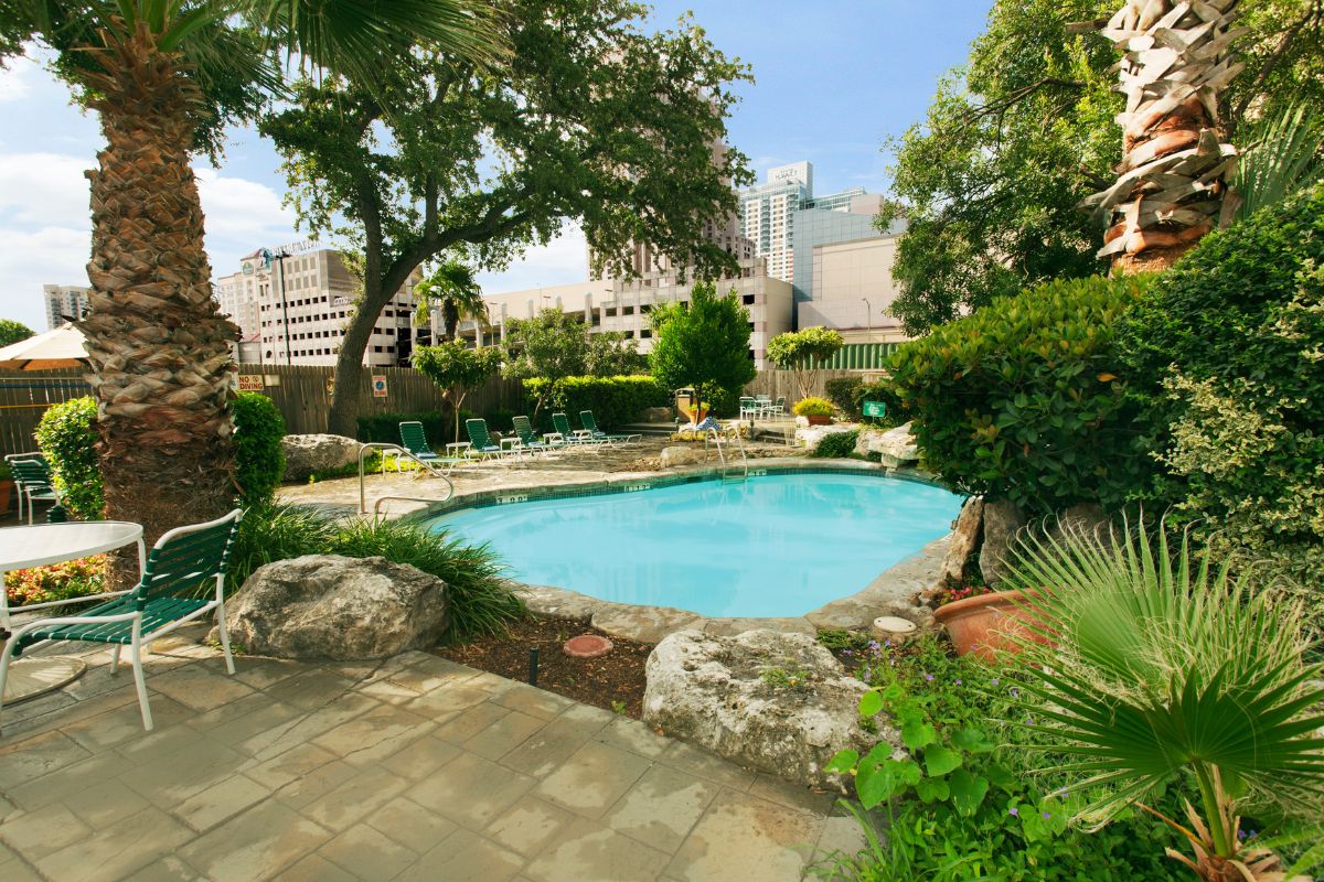a pool with chairs and trees around it
