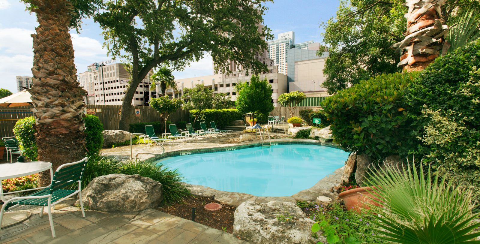 a pool with a lawn chair and trees around it