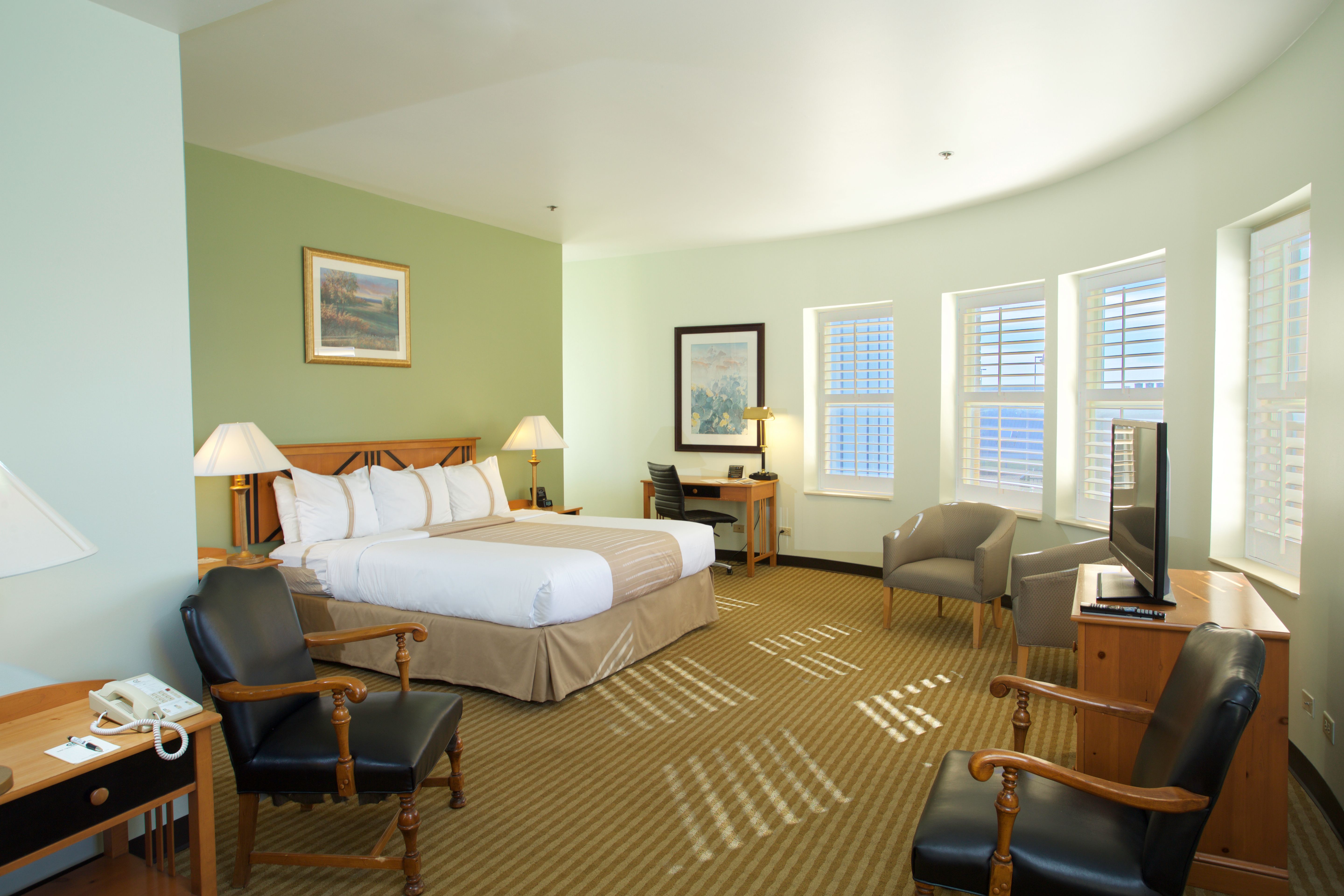 a room with a bed and chairs