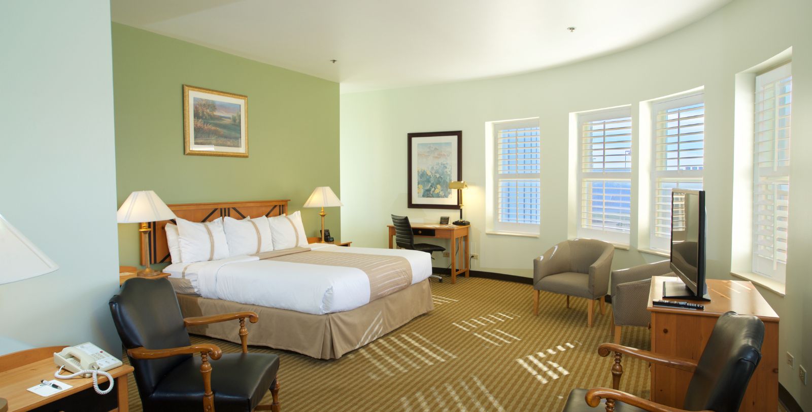 a hotel room with a bed and chairs