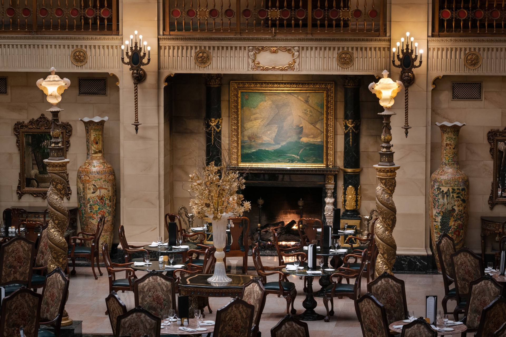 a room with a fireplace and tables and chairs
