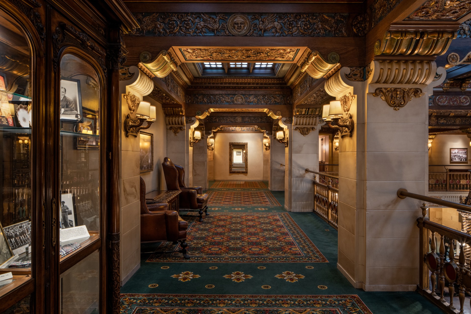 a hallway with ornate ceiling and chairs