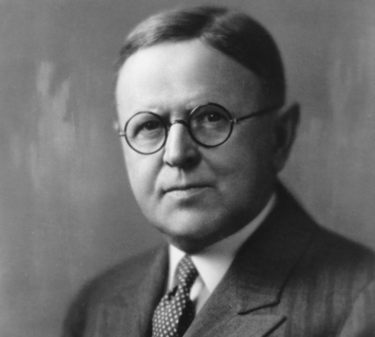 a man wearing glasses and a suit