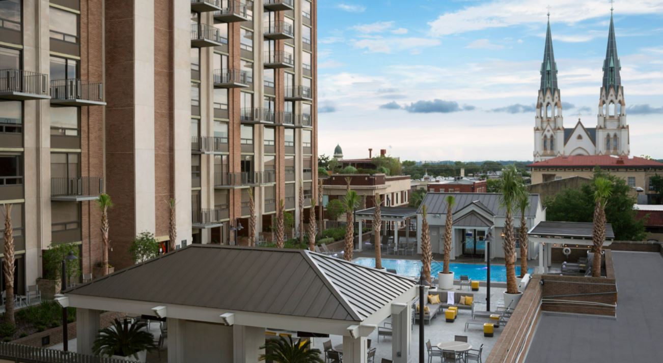 a pool and building with palm trees