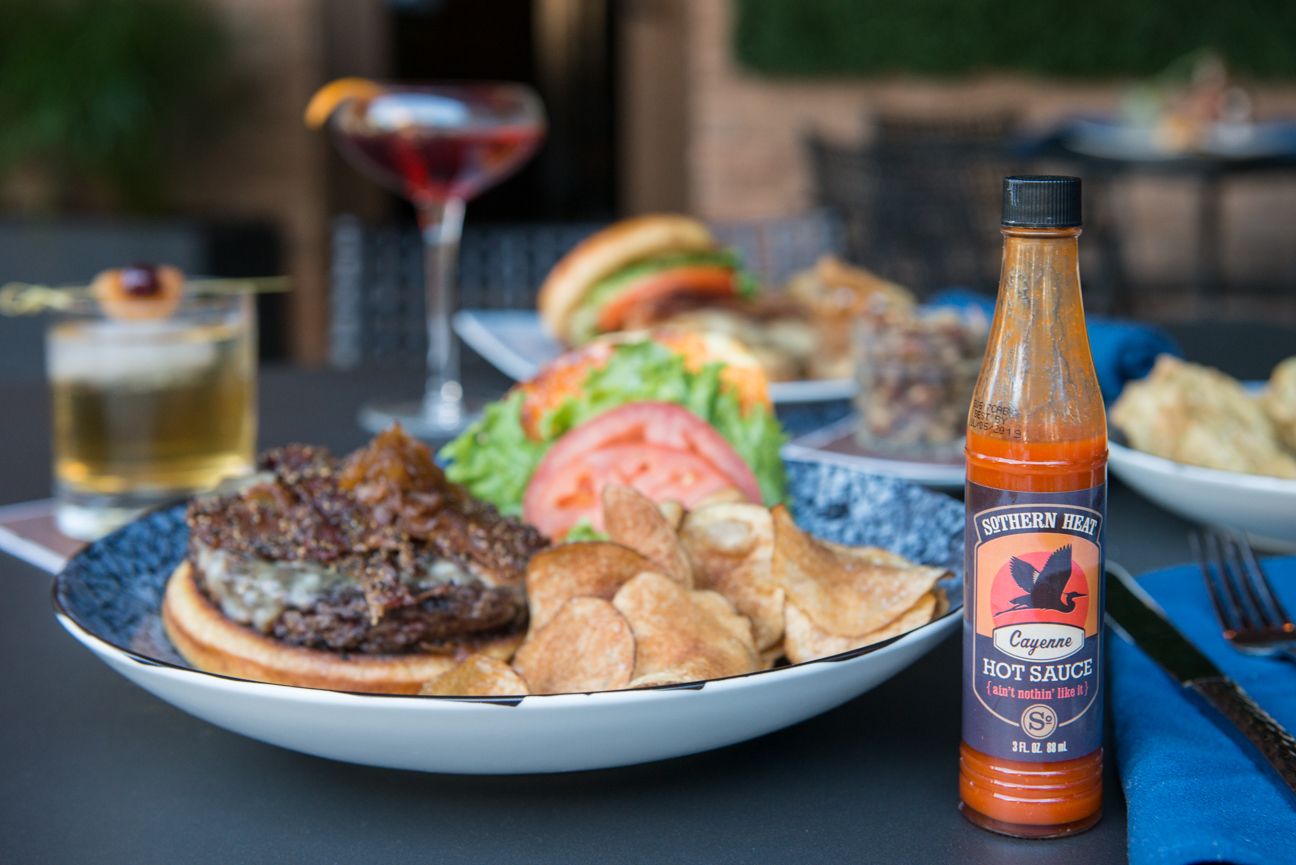a plate of food and a bottle of hot sauce