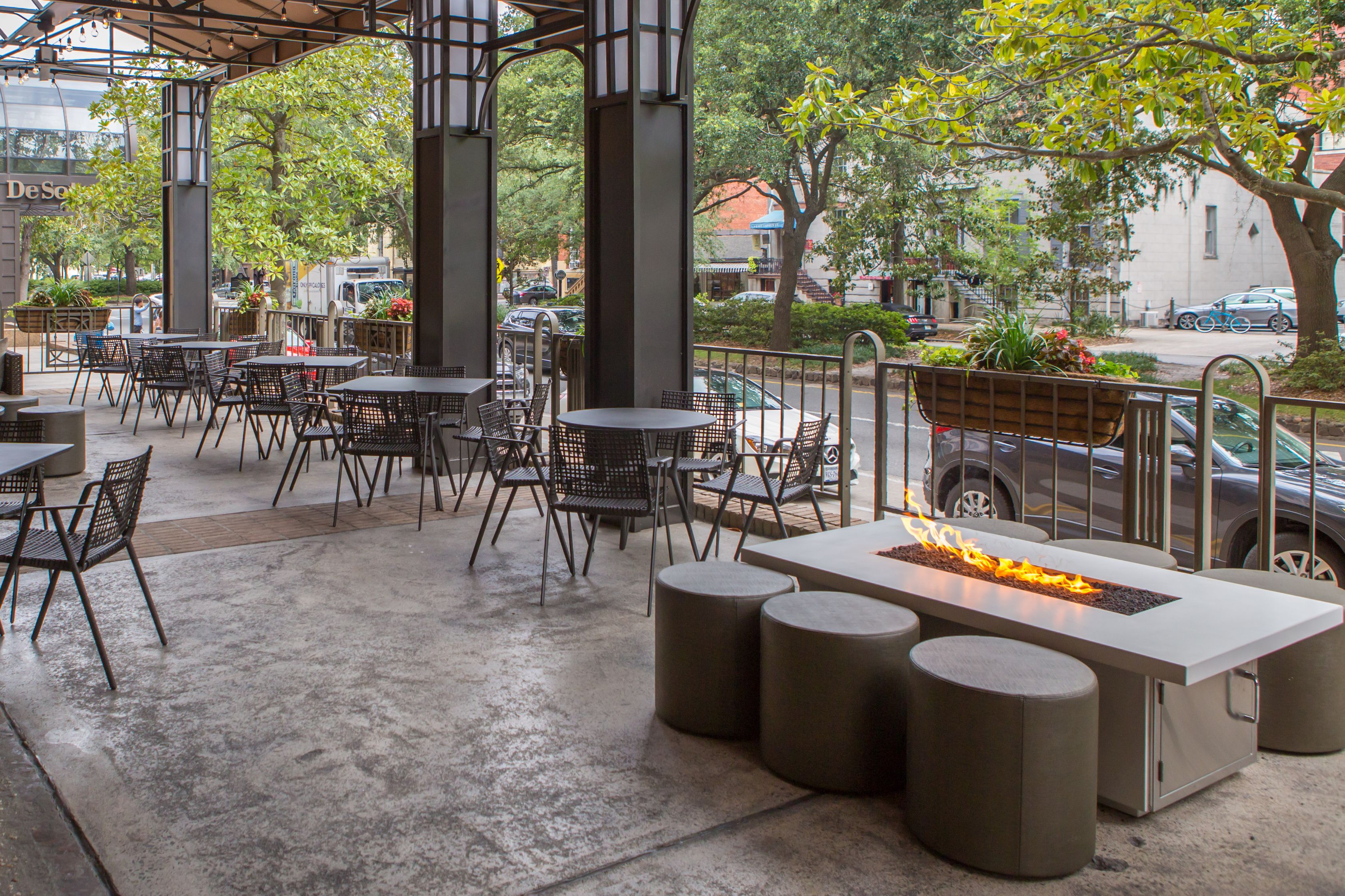 a patio with tables and chairs and a fire pit